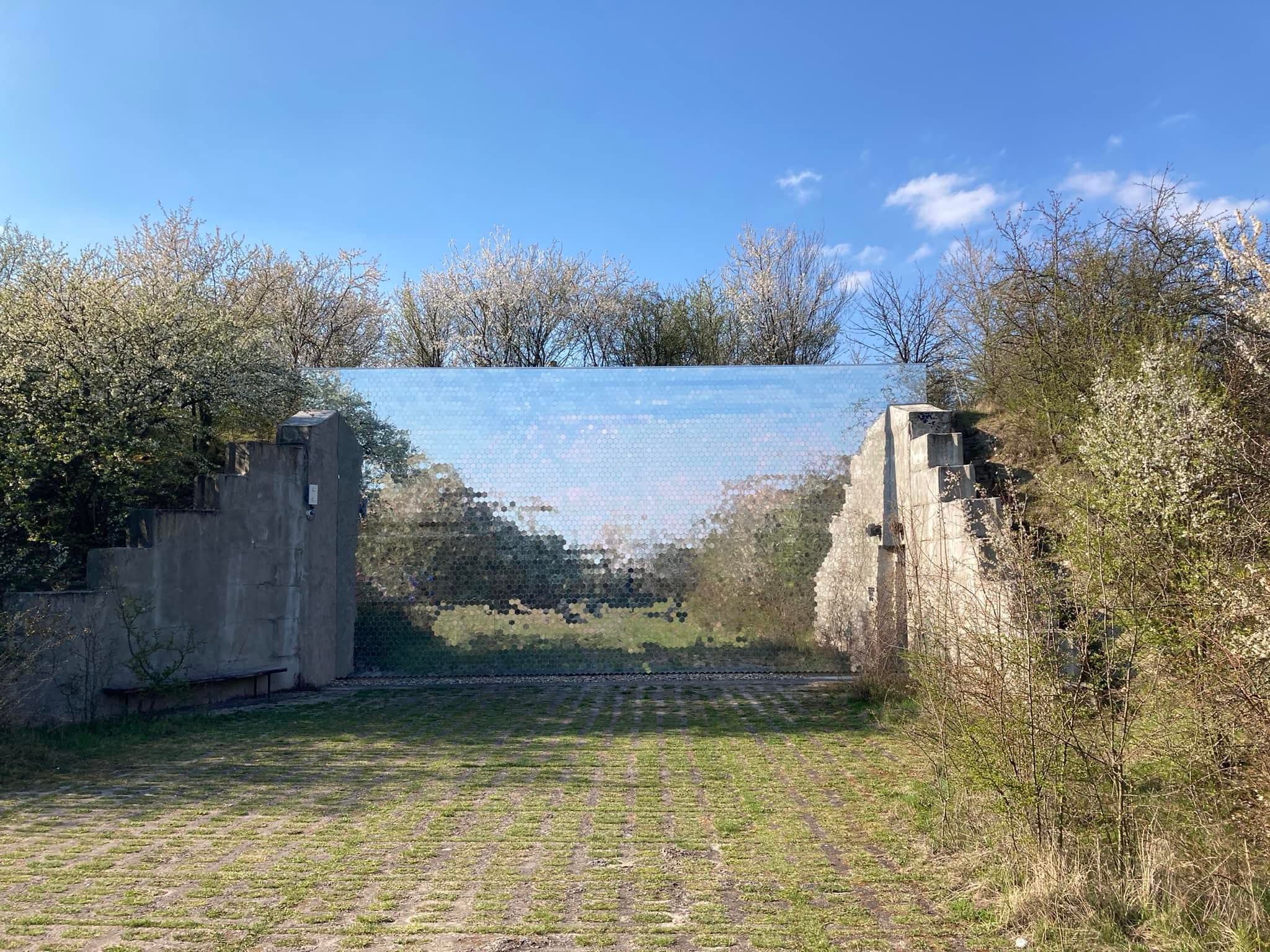 Krematorium Věčná loviště – zrcadlová stěna obklopená kvetoucí přírodou